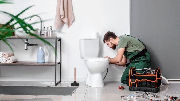 Loodgieter repareert wc met gereedschap